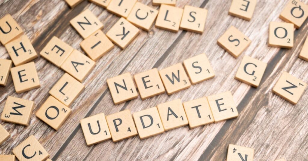 Scrabble tiles spelling 'News Update' on a wooden background, ideal for media and communication concepts.