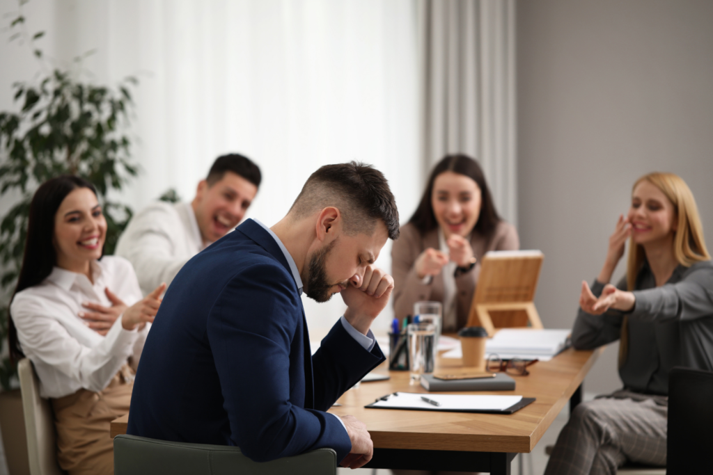 coworkers bullying their colleague at workplace in office