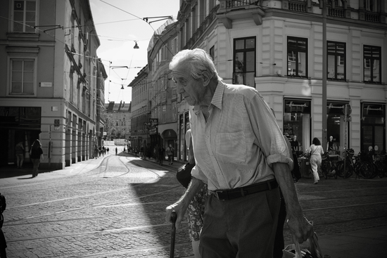 Elderly Man Walking in European City Street